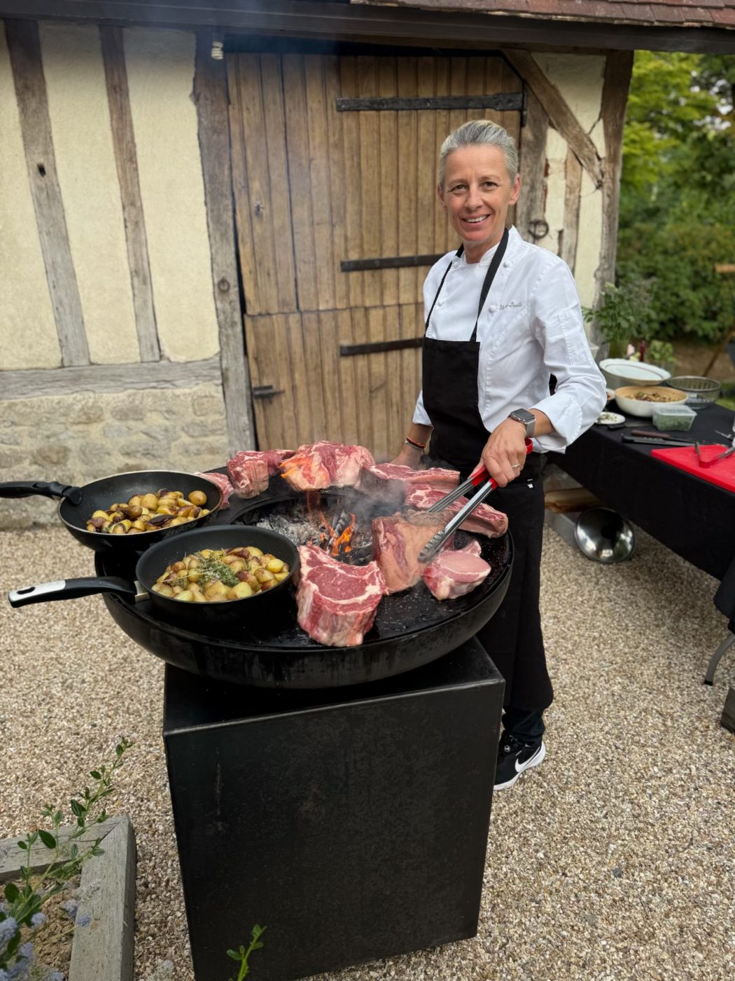 Cuisine au feu de bois devant une longère normande à colombages